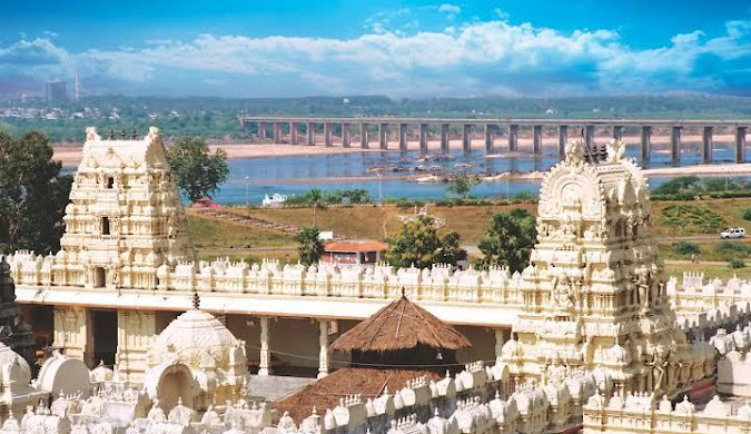 A scenic view of Badhradhri Temple with intricate carvings and devotees at its entrance.