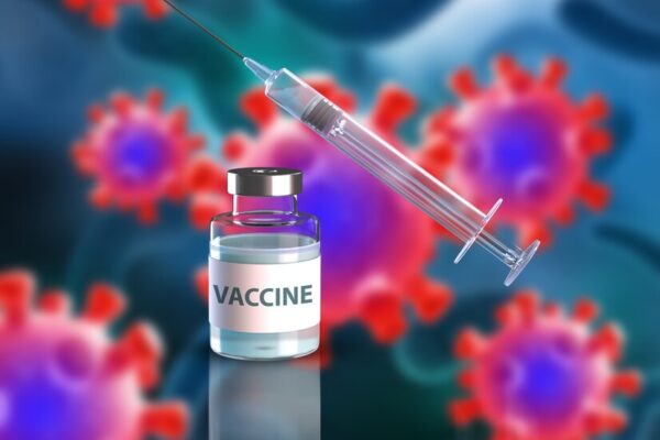 A scientist in a laboratory holding a vial labeled "mRNA Cancer Vaccine" with a Russian flag in the background.